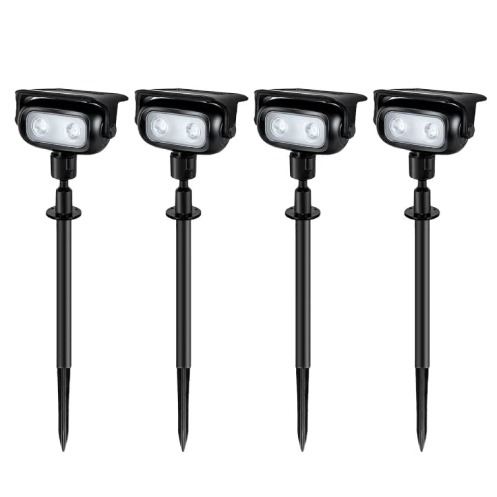 Bright solar spot lights illuminating garden shrubs at dusk